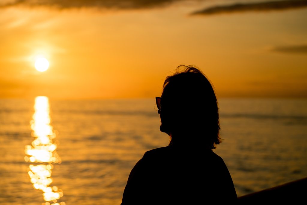 A middle-aged woman looking out at the sea.