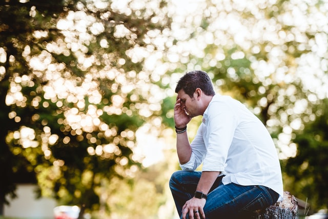 sitting man with head in hands