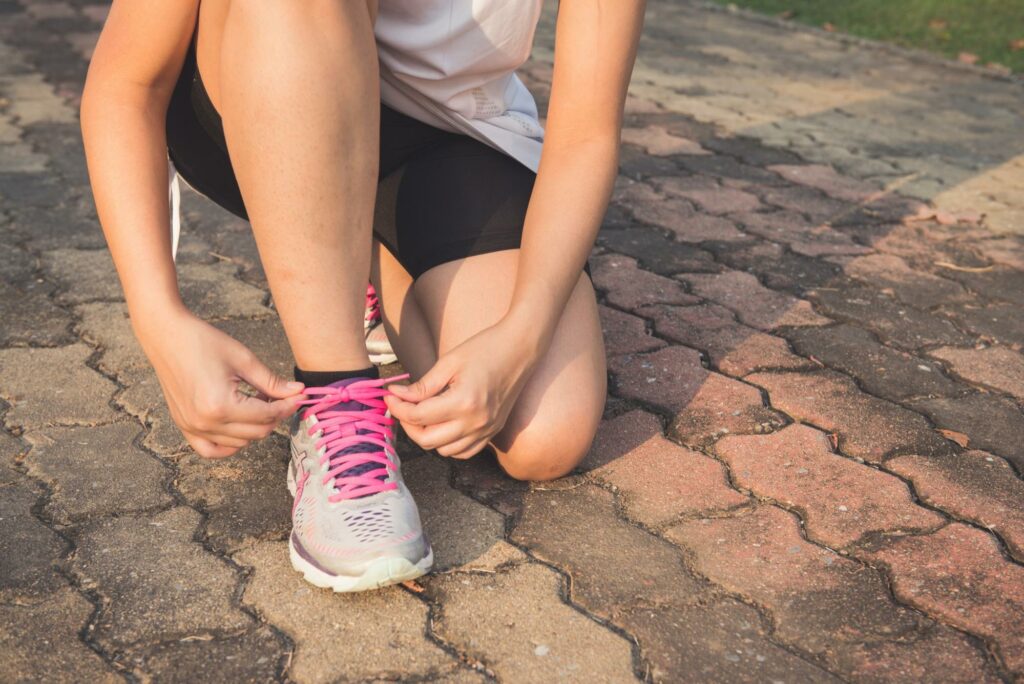 losing weight with metabolic syndrome,
Running shoes - woman tying shoe laces.
