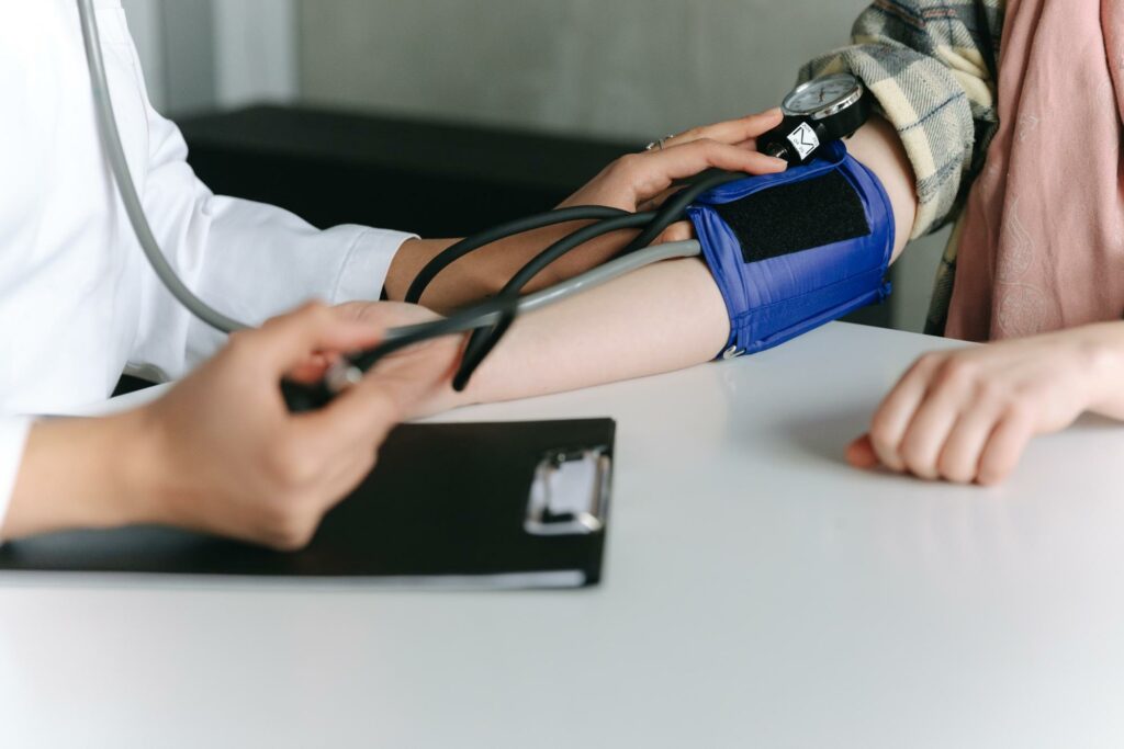 testing for metabolic syndrome, young doctor checking blood pressure
